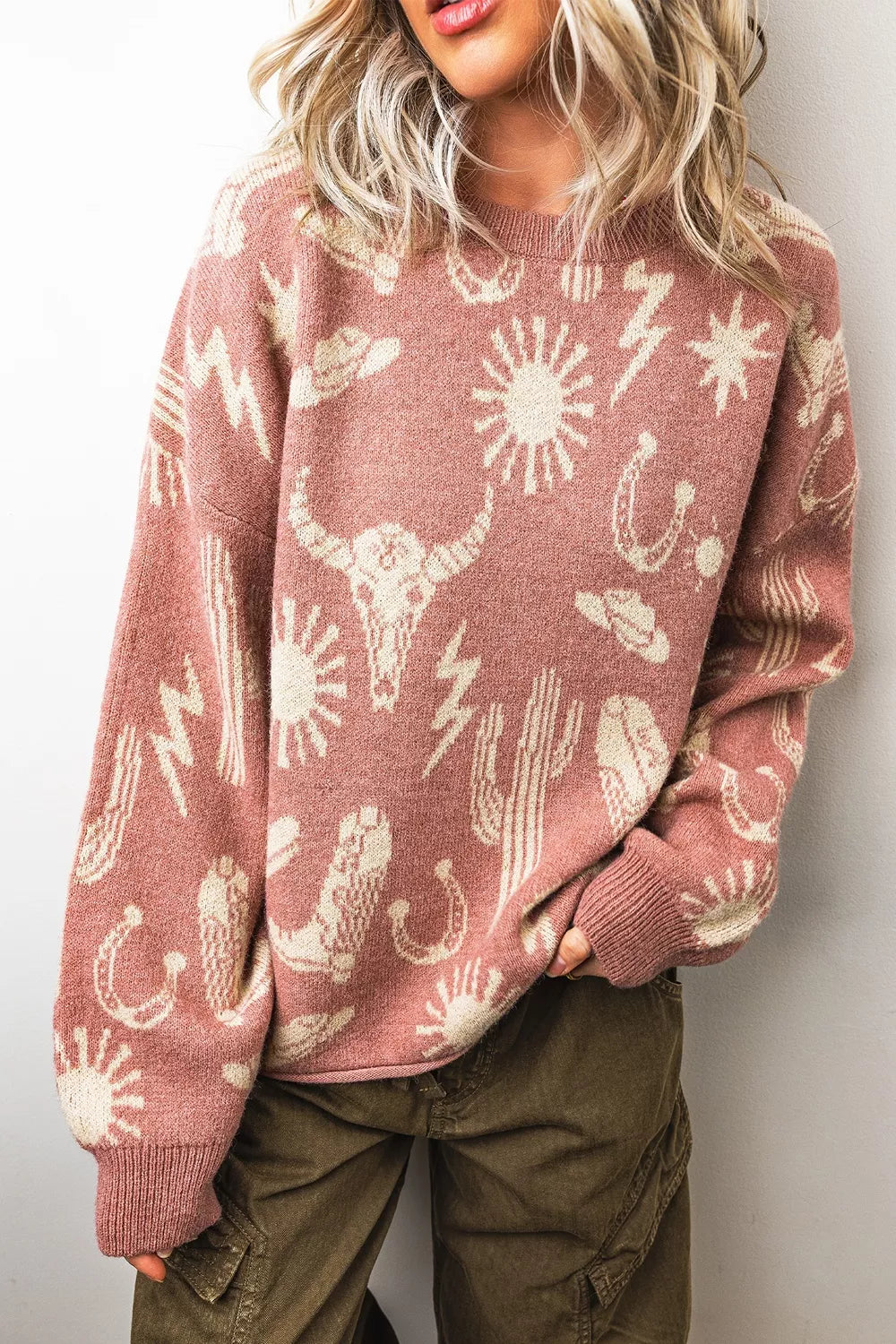 On-model front view of the dusty rose sweater with longhorn, cactus, and horseshoe motifs