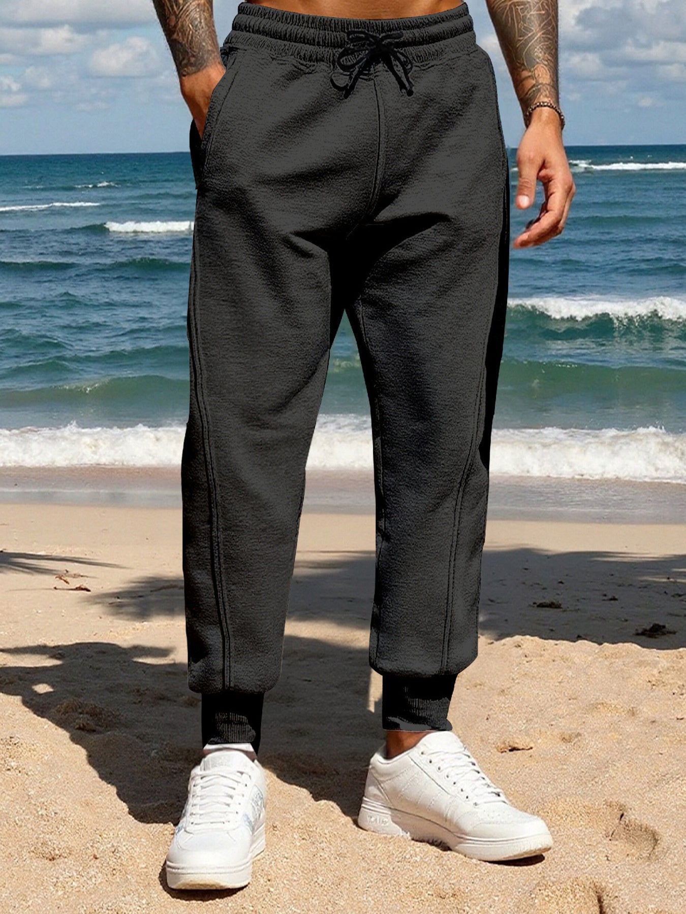 Men's black casual joggers with a drawstring waist and pockets.