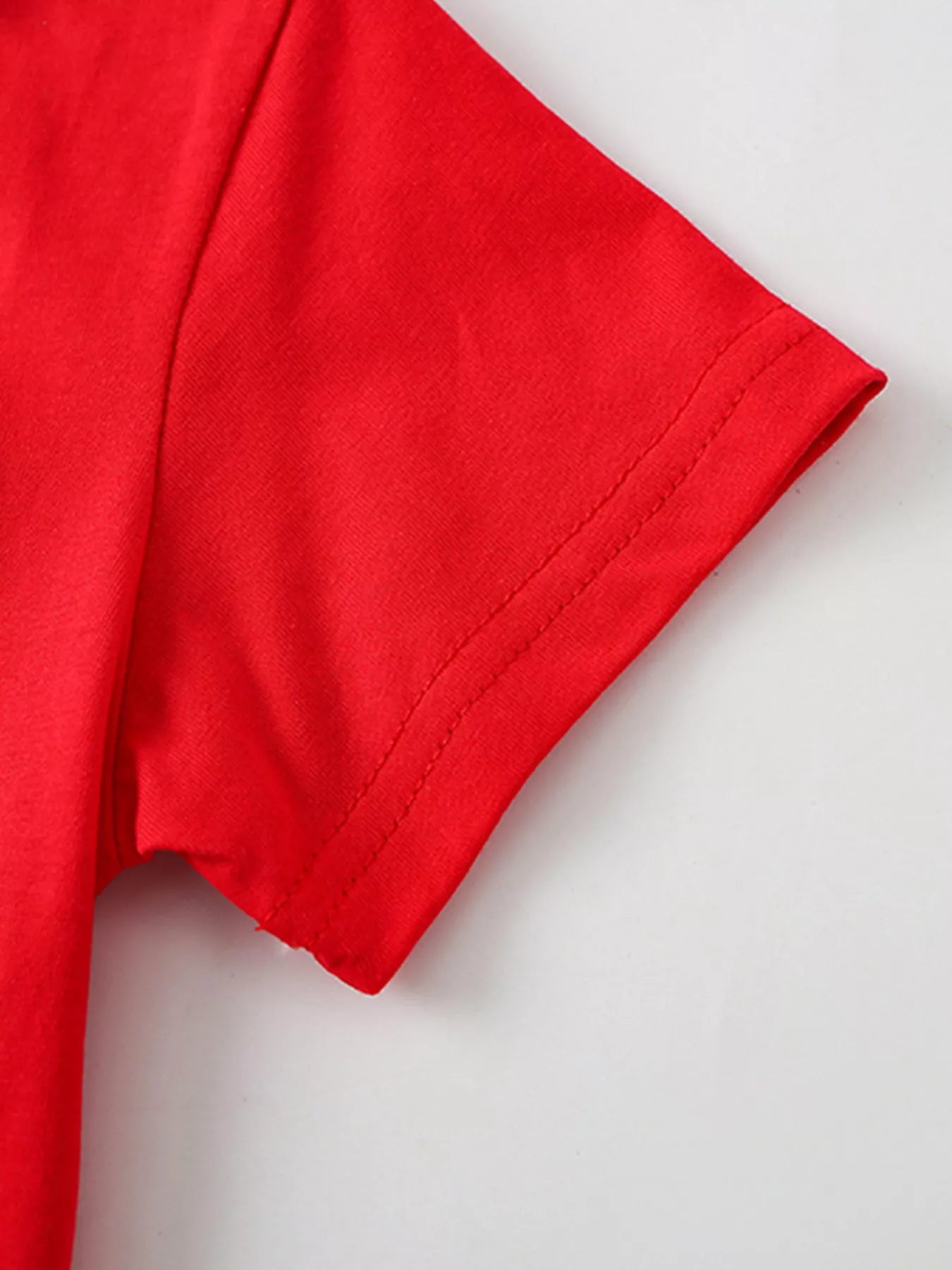 Close up of the plain red short sleeve hem with double stitching on a children's tee