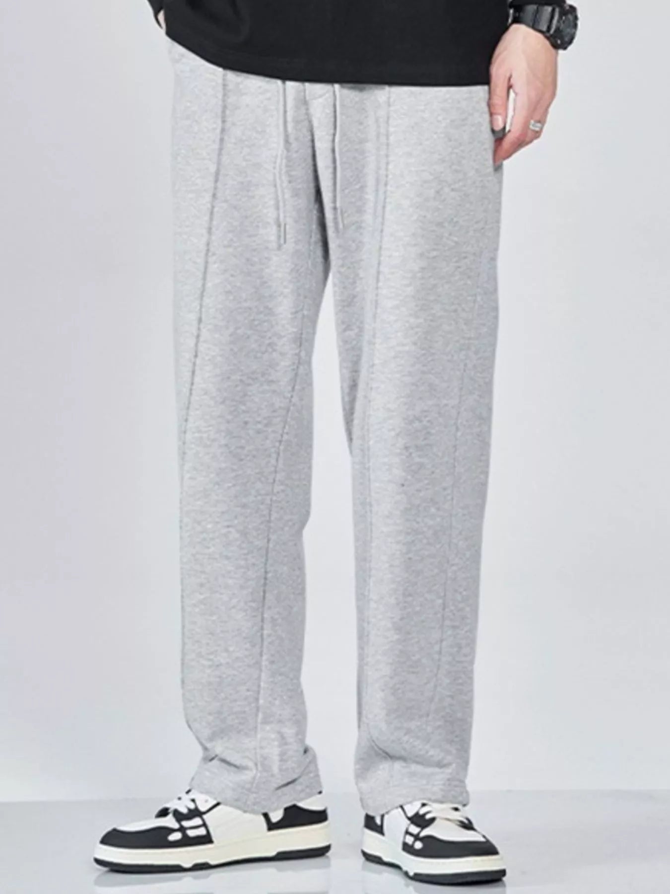 Men's wide-leg sweatpants with a drawstring waist and pockets in the light gray color.