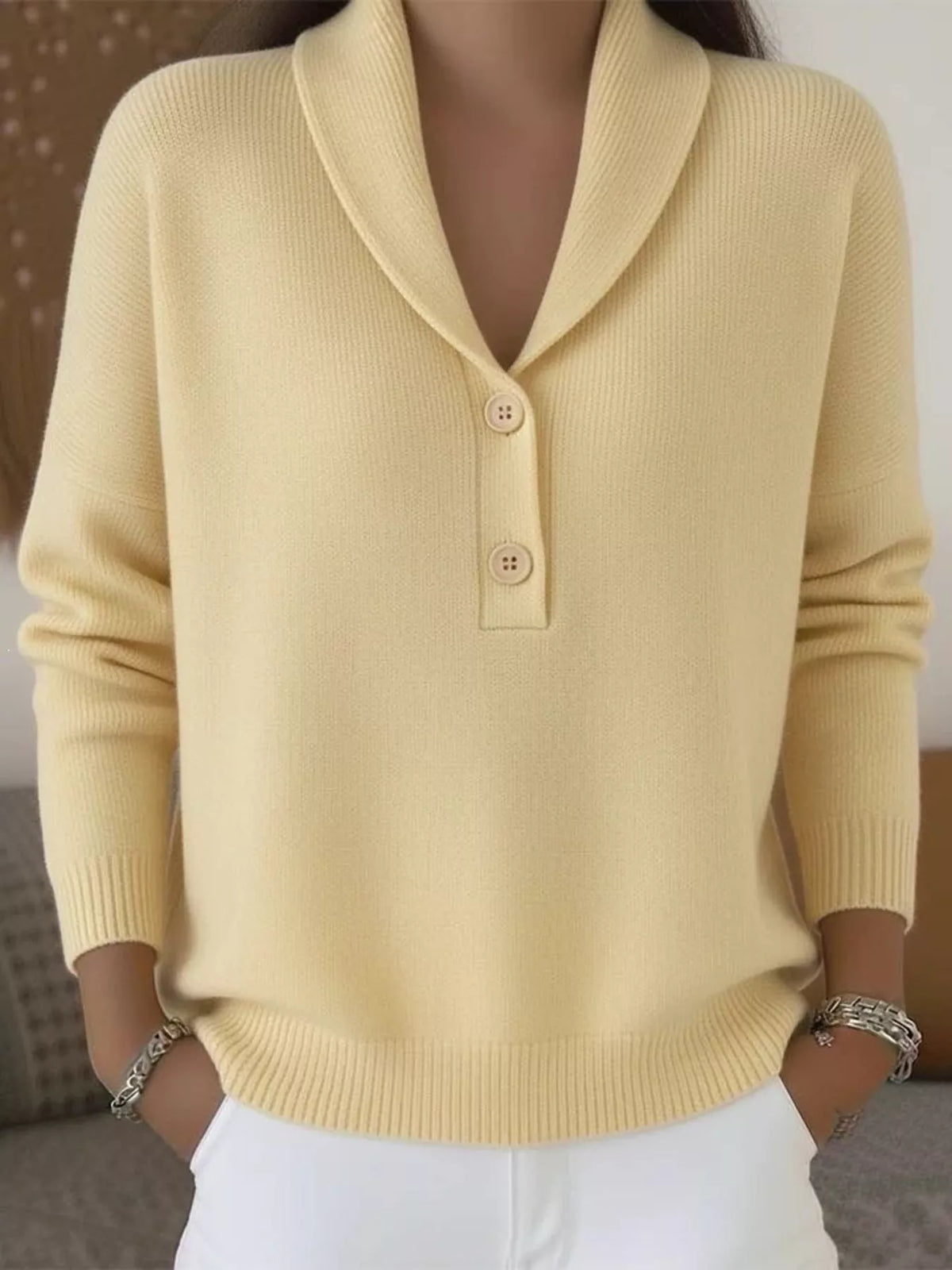 On-model front view of a pale yellow shawl collar sweater with two buttons