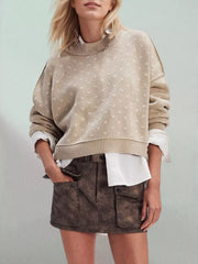 Khaki dotted knit sweater with ribbed crew neck and dropped shoulders worn layered over a white shirt