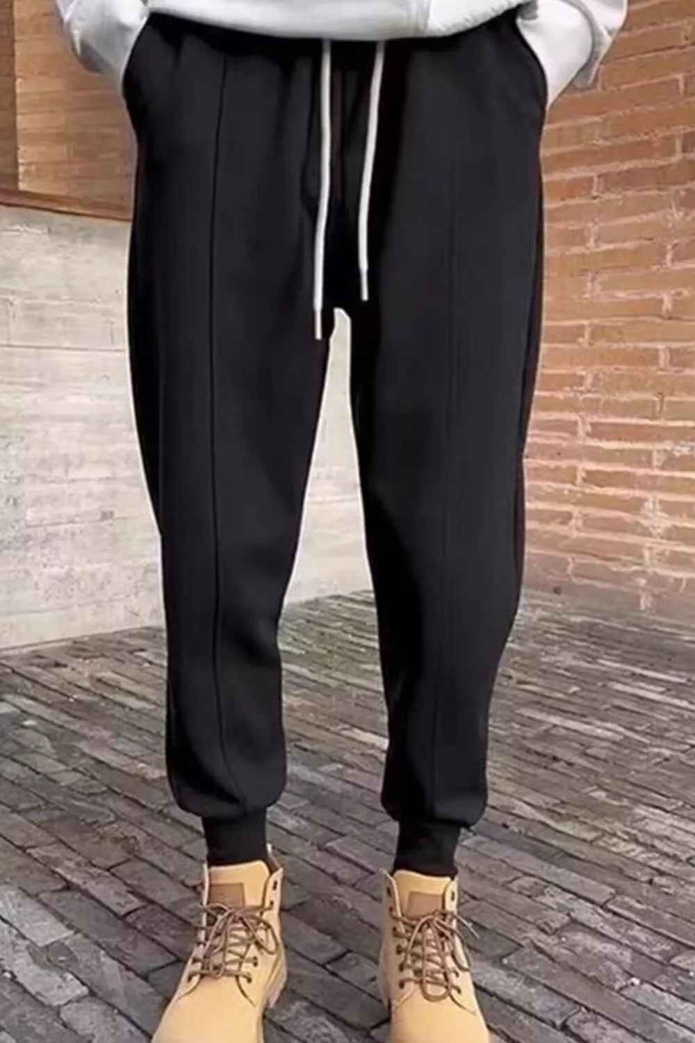 Men's black loose-fit joggers with a drawstring waist and pockets.