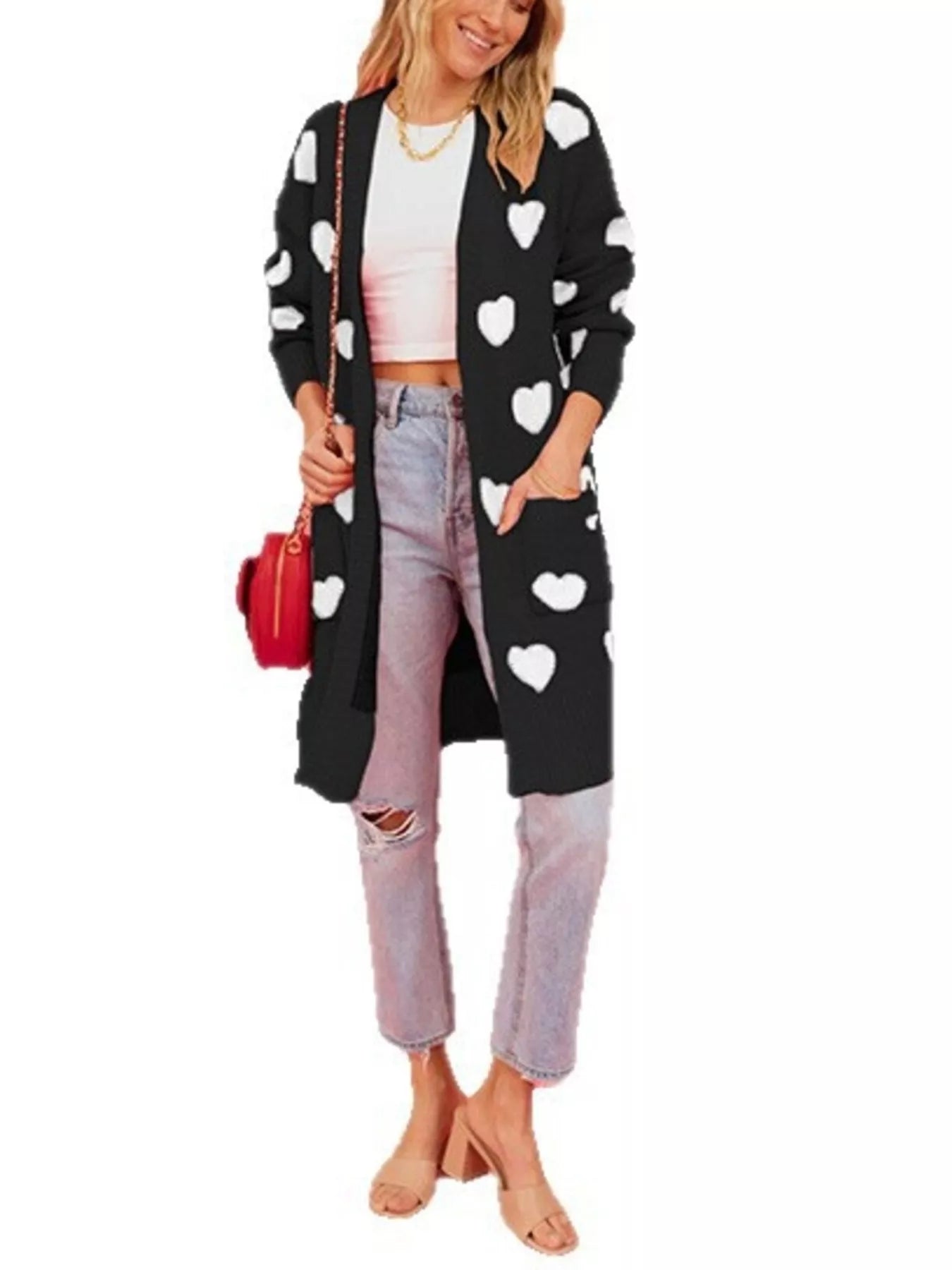 Full length view of the black heart print cardigan over light wash jeans