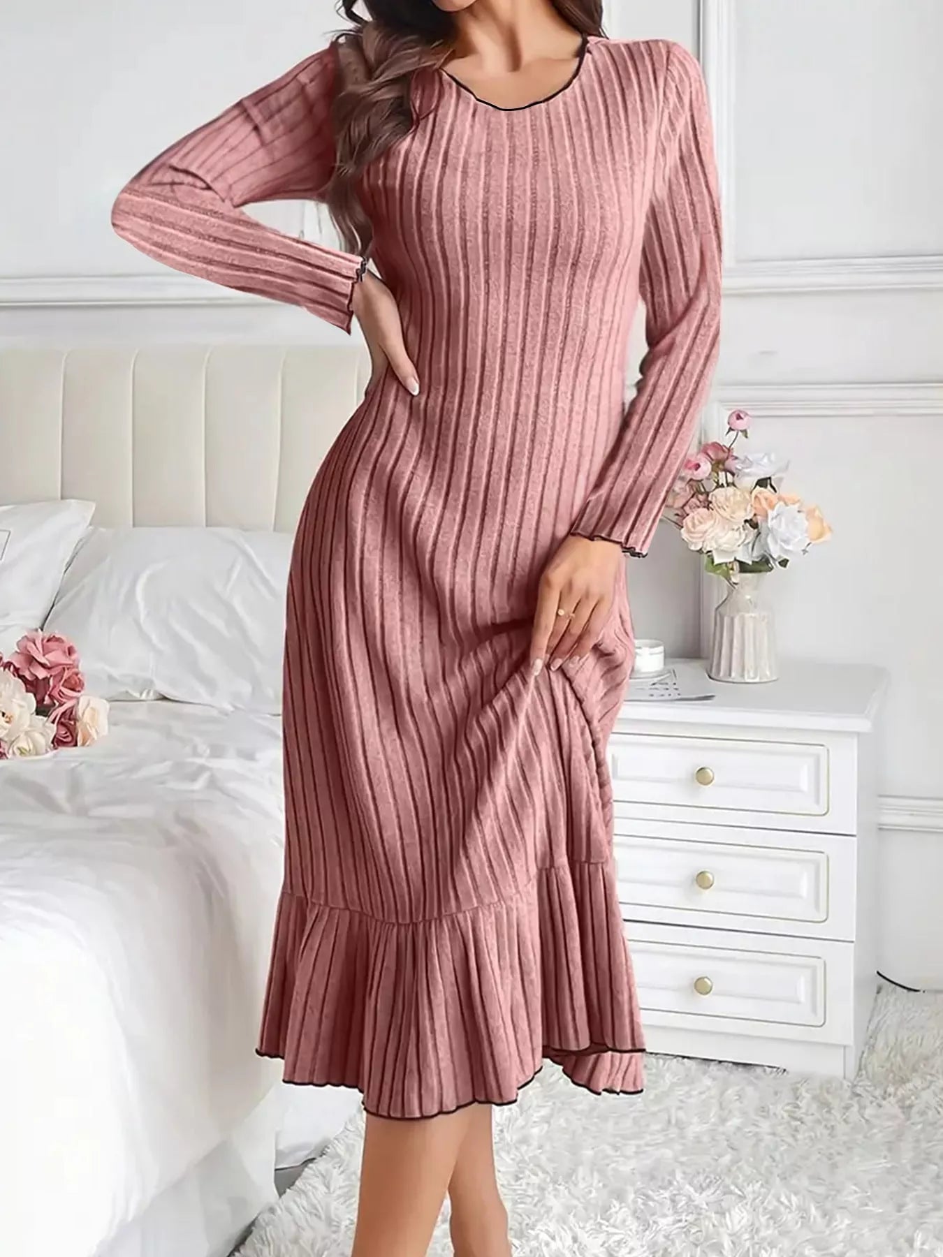 Dusty pink ribbed knit bodycon dress with ruffle hem, front view with hand on hip