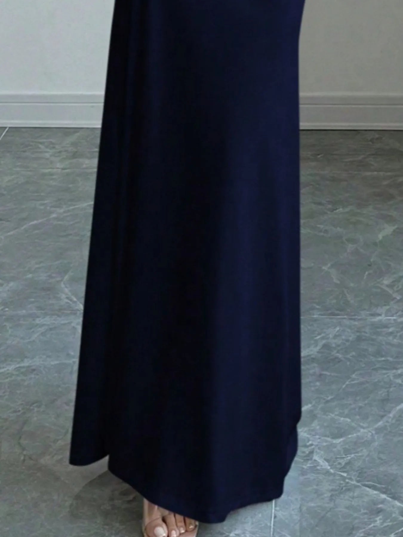 Close view of navy blue off shoulder maxi skirt hem and floor length fabric