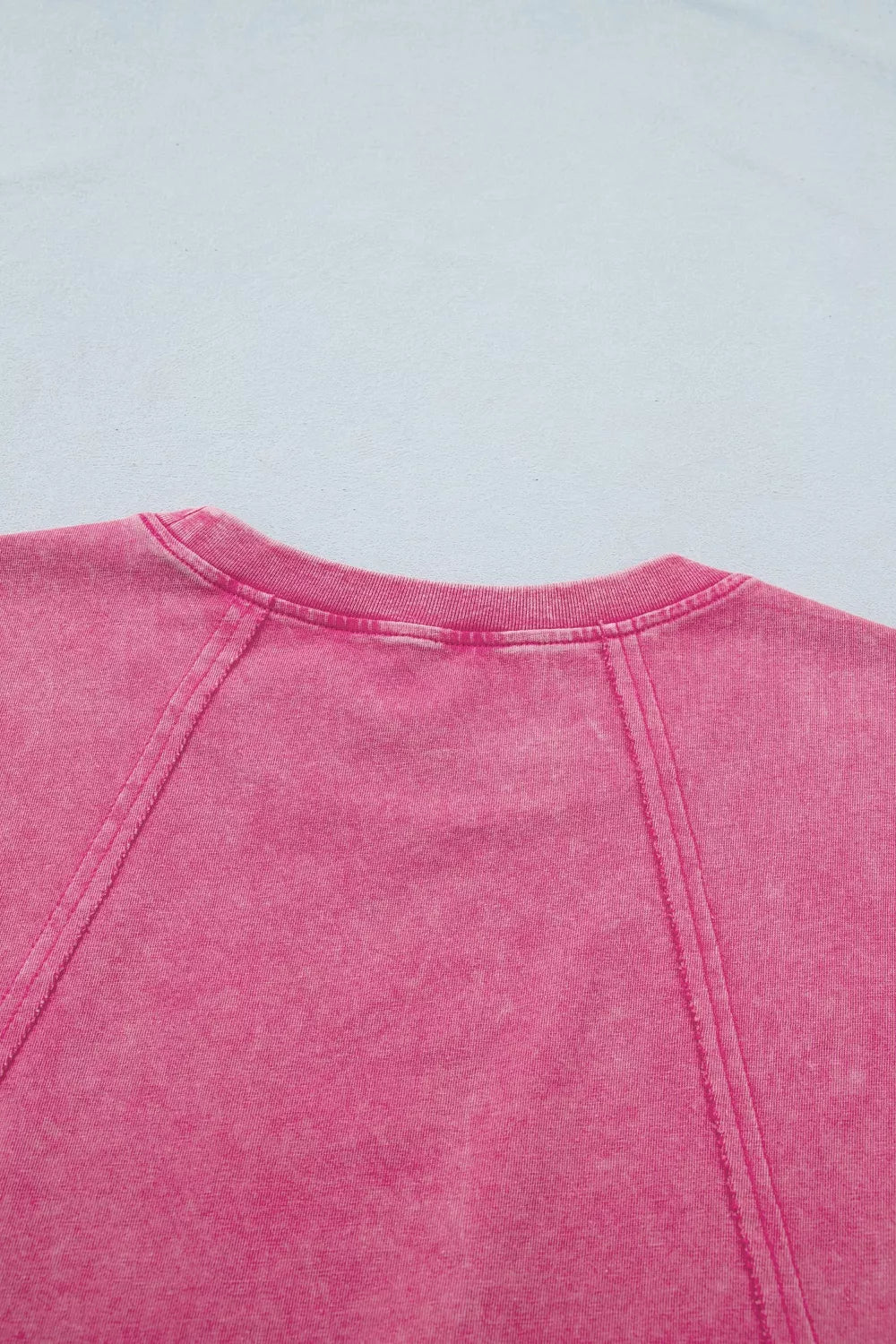 Close-up of pink mineral-wash top showing ribbed