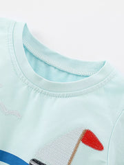 Close-up of the mint blue shirt neckline and the embroidered white sail with red flag