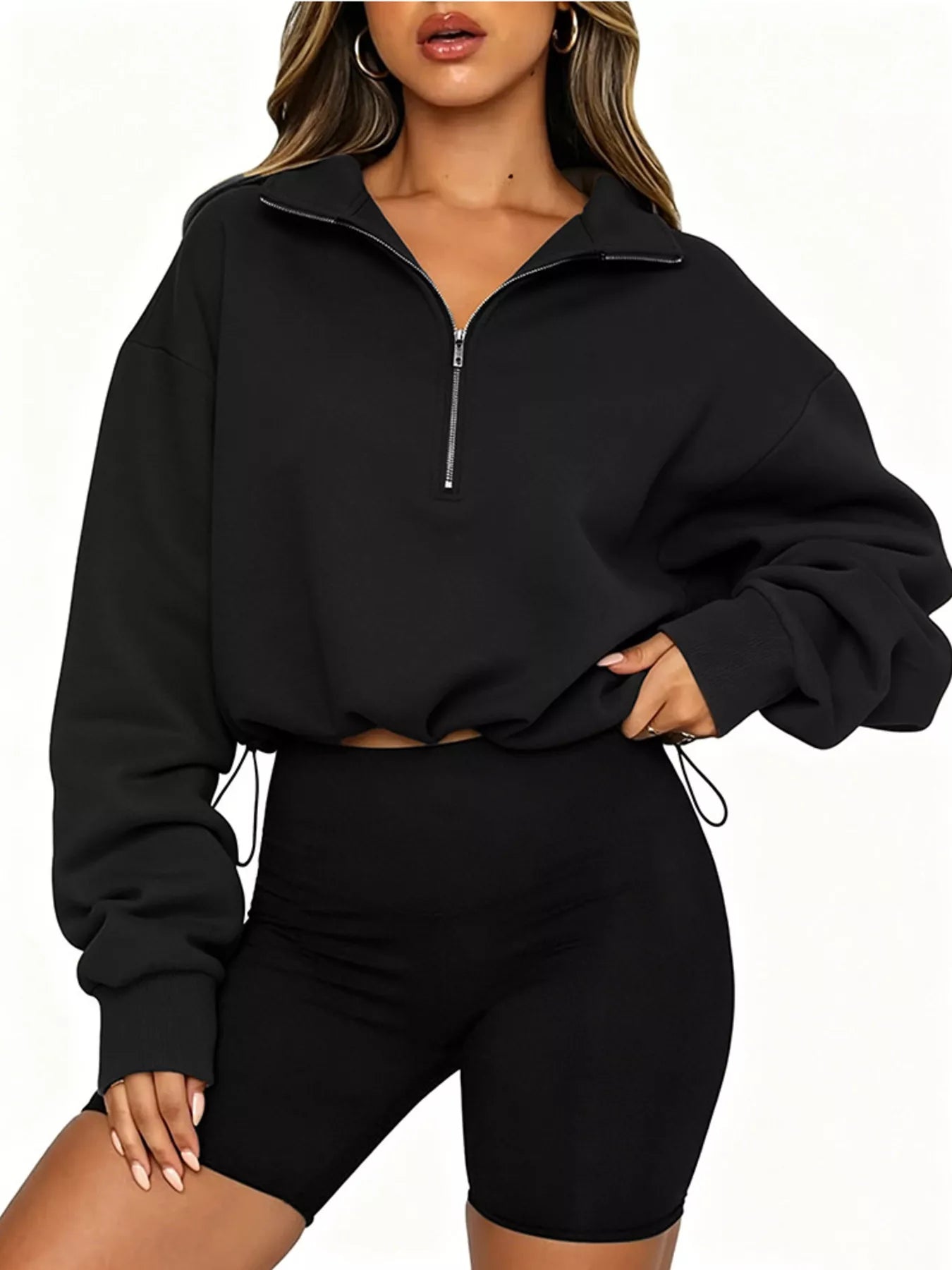 Front angled view of black half zip sweatshirt with drawstring hem and long sleeves