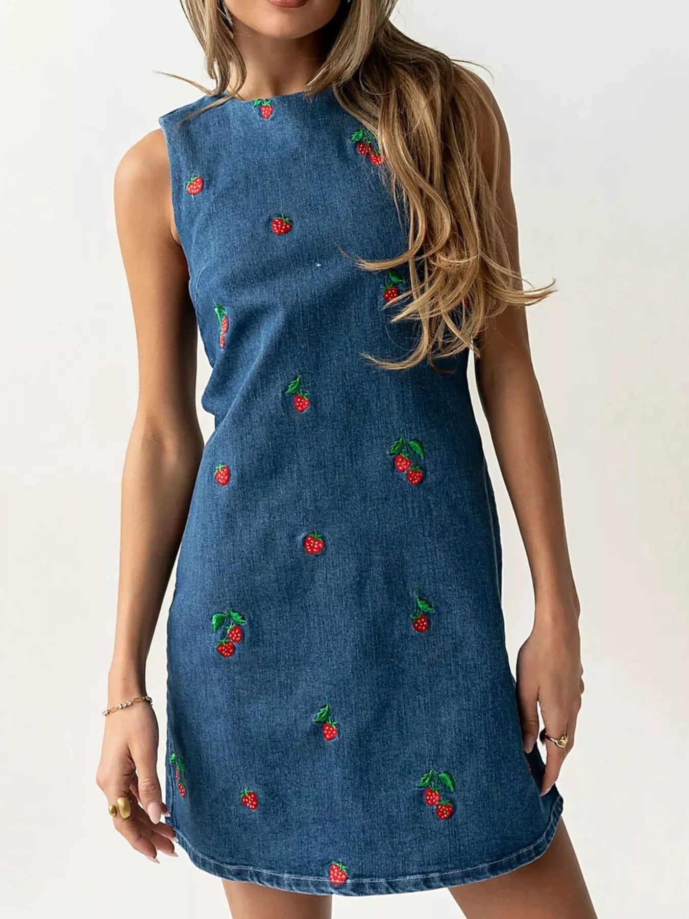 Blue sleeveless denim dress with scattered red strawberry embroidery in front view