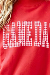 Close chest detail of red mock neck sweatshirt showing plaid GAME DAY lettering