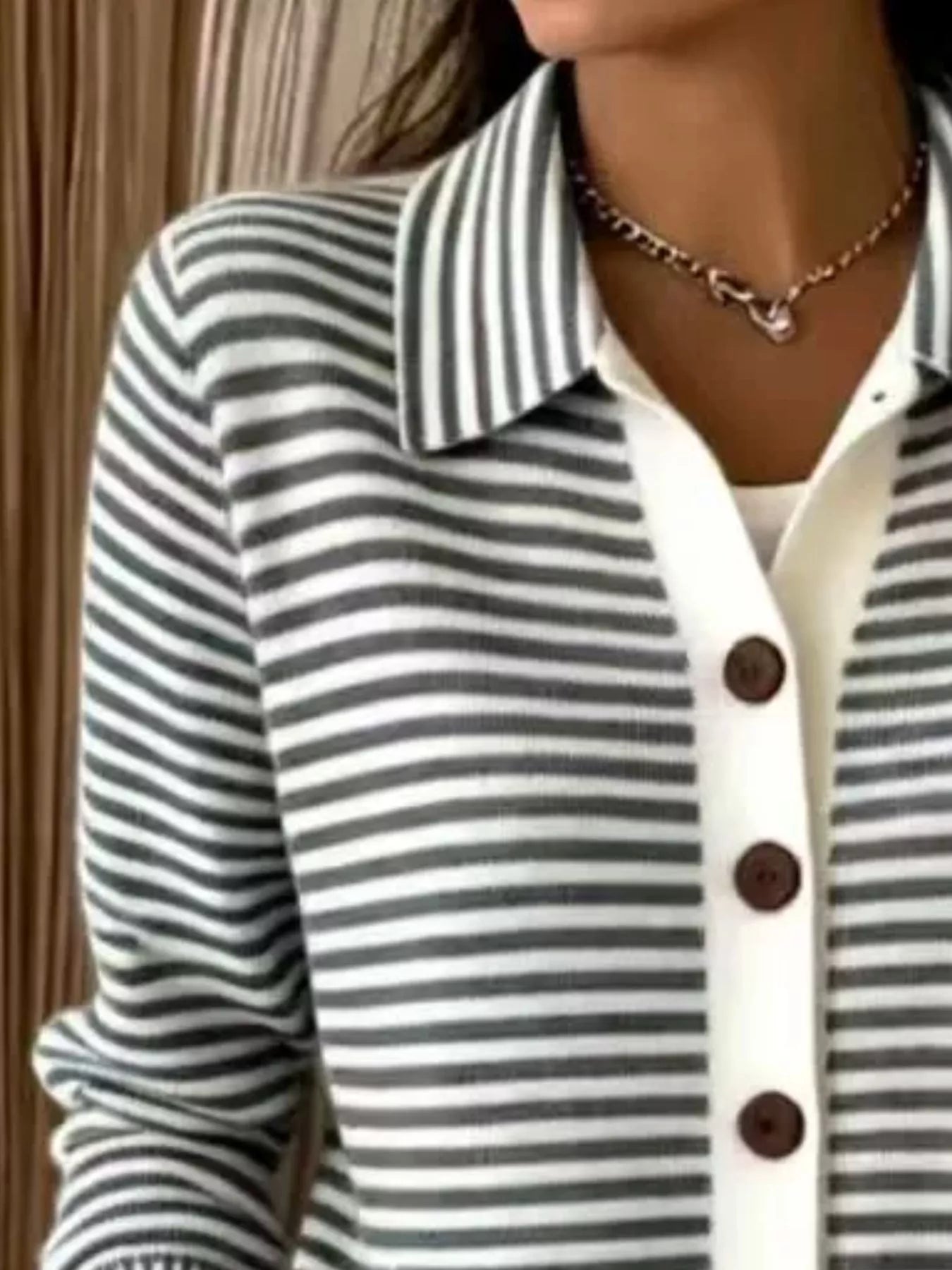 Close-up on-model view of black and white striped collared cardigan with brown buttons