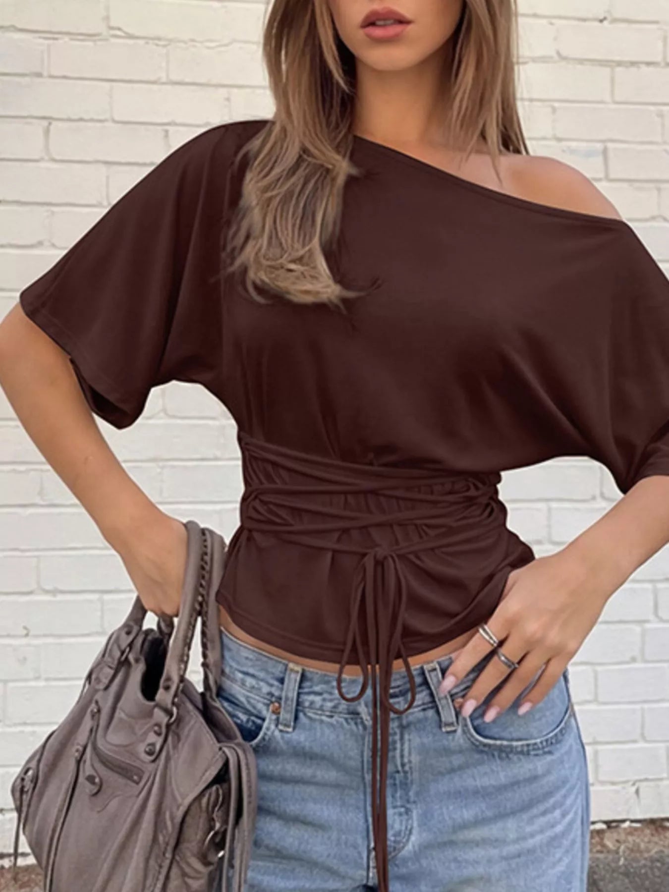 Brown boat-neck short-sleeve T-shirt styled with a gathered waist and drawstring over blue jeans