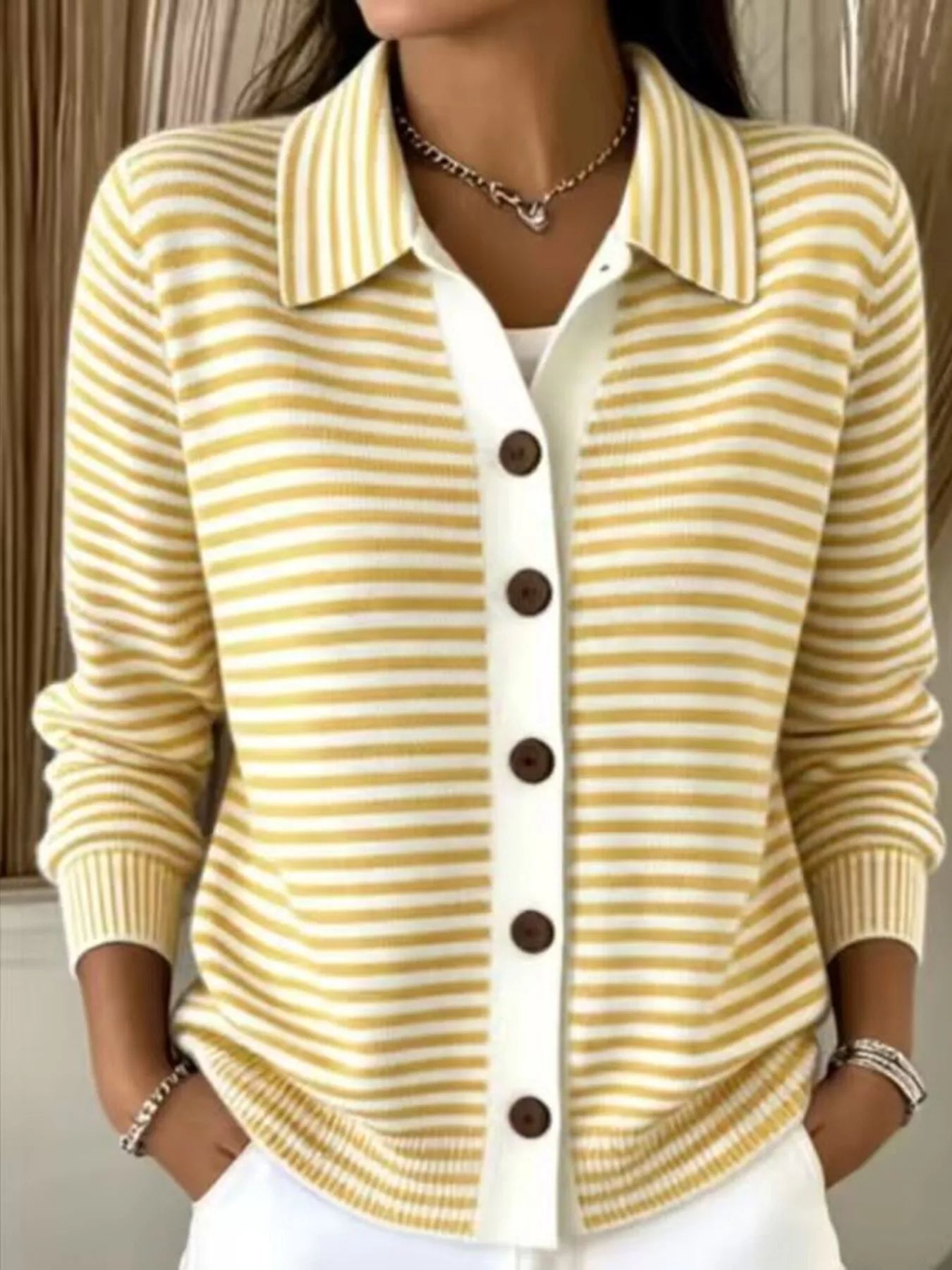 On-model front view of yellow and white striped collared cardigan with brown buttons