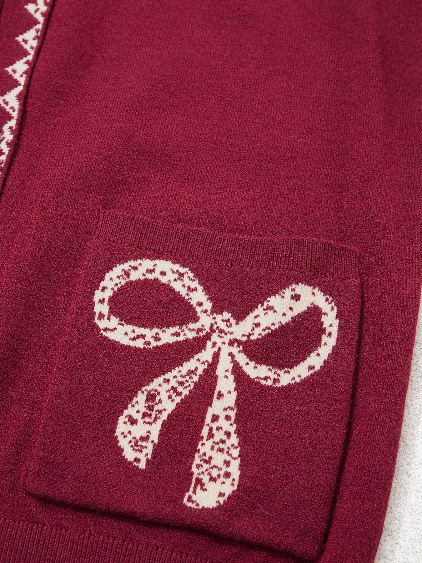 Close view of the burgundy bow pocket with cream lace bow detail