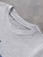 Close up of the light gray round neckline and fine stitching on the children's T-shirt
