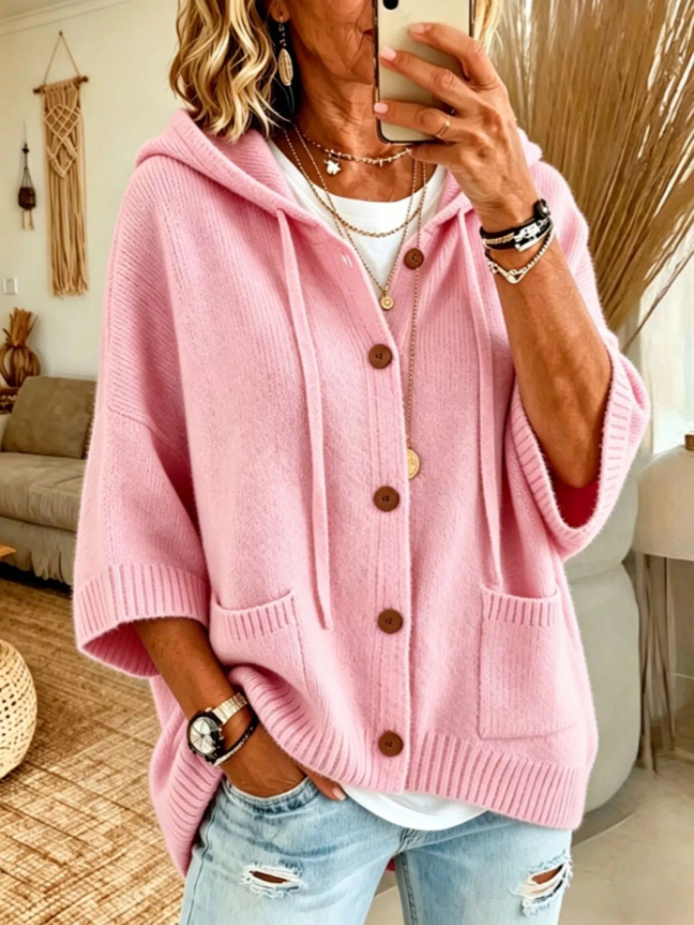 Pink hooded knit cardigan with brown buttons and patch pockets shown from the front on model