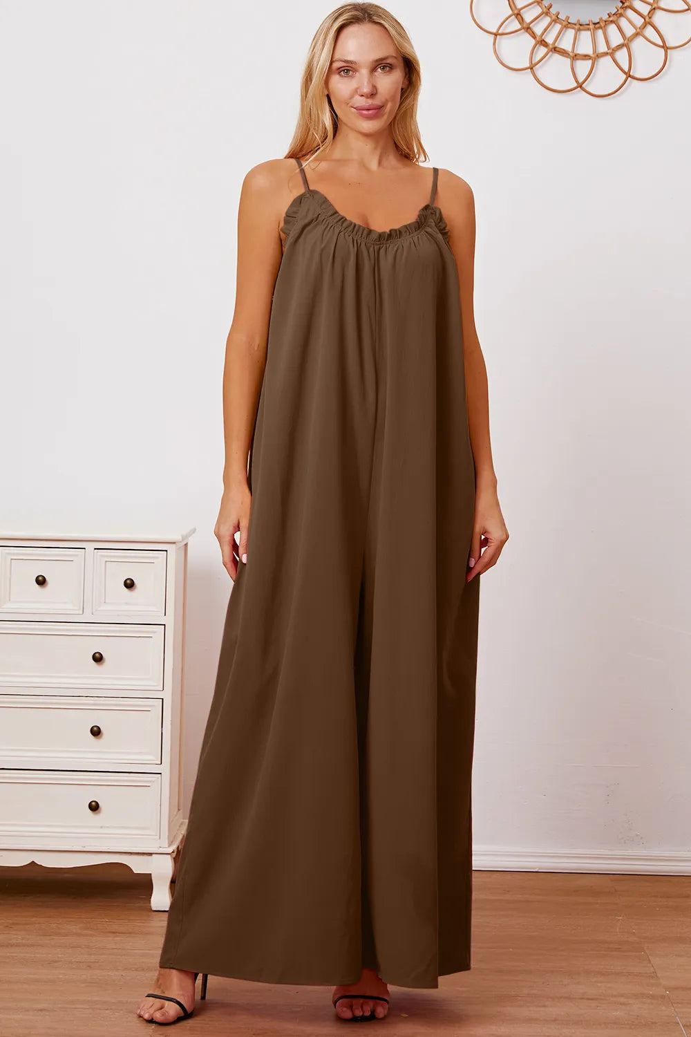 Women's cami jumpsuit with ruffle trim, a tie back, and pockets.
