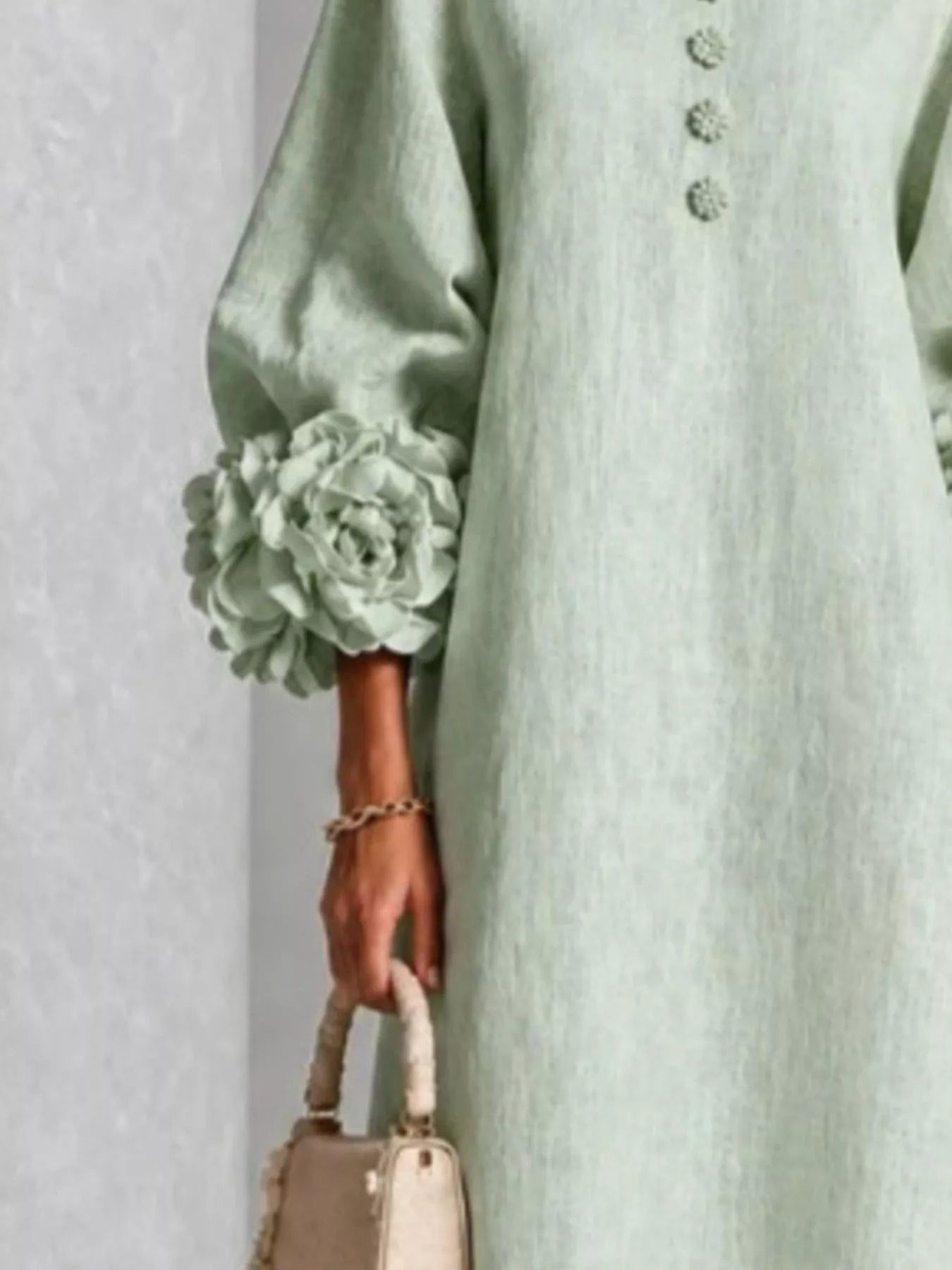 Close detail of the sage midi dress sleeve with a large floral cuff and small floral front buttons
