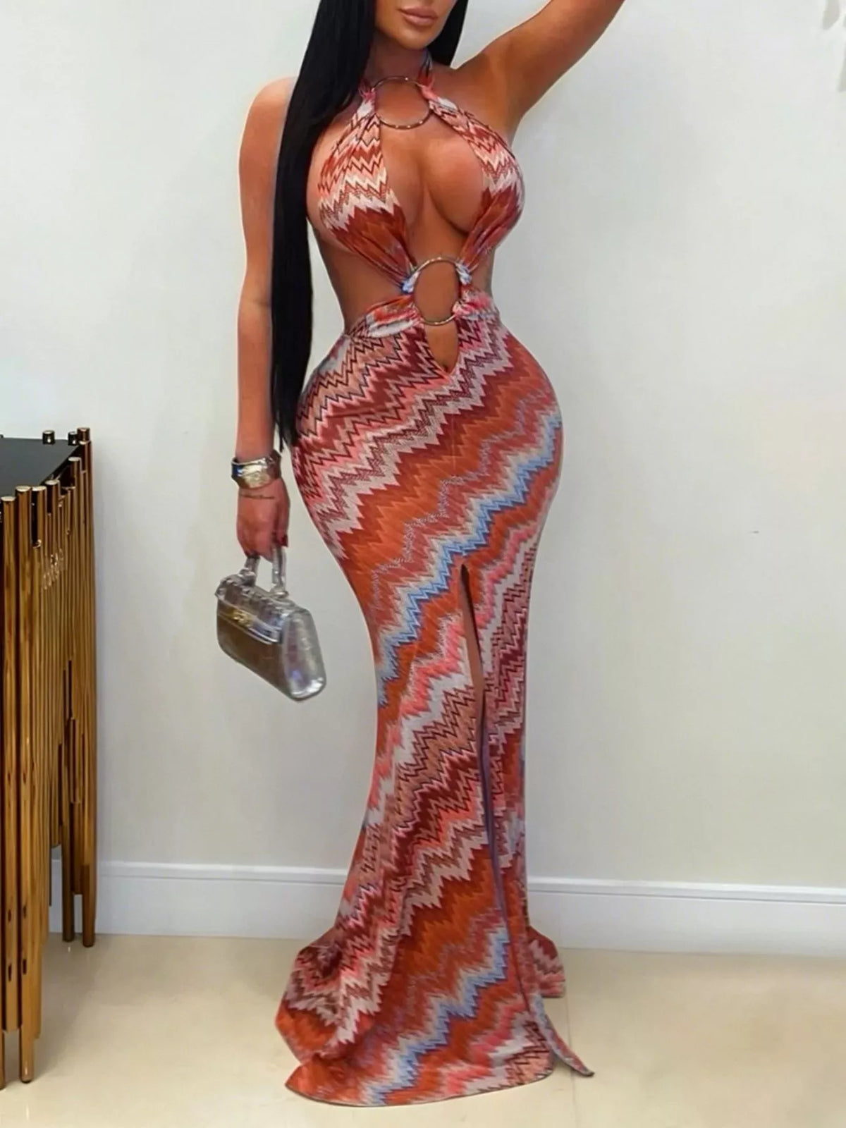 Rust chevron halter maxi dress with ring cutouts and front slit worn indoors