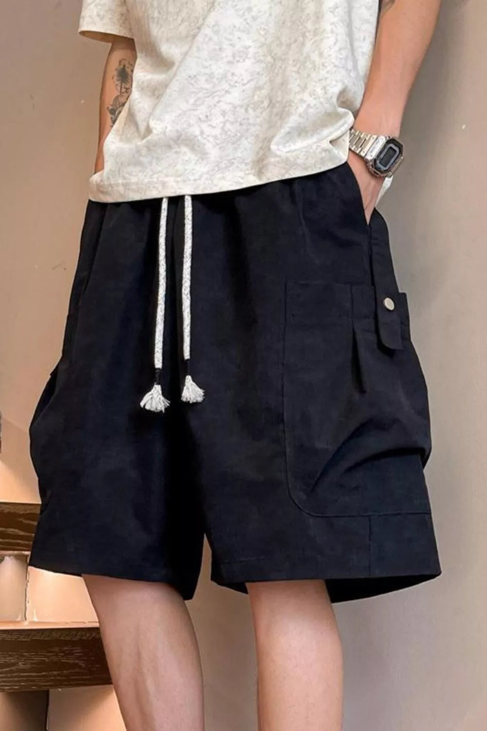 Men's black drawstring shorts with pockets and lightweight fabric.