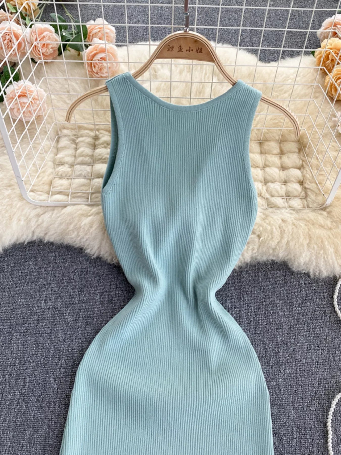 Front bodice of mint ribbed knit sleeveless bodycon midi dress on hanger