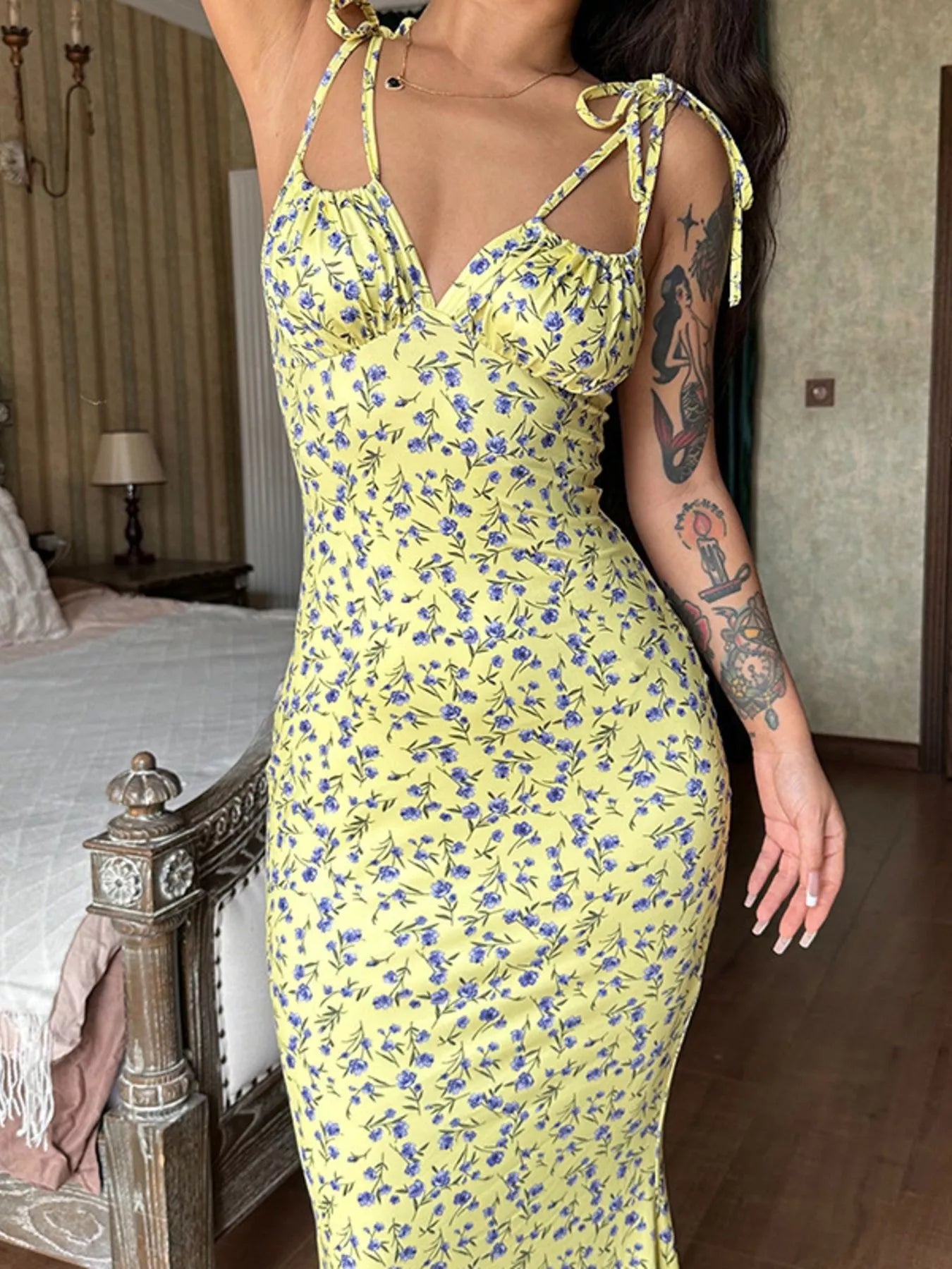 Close up of yellow floral print bodycon maxi dress bodice with tie straps and ruched neckline