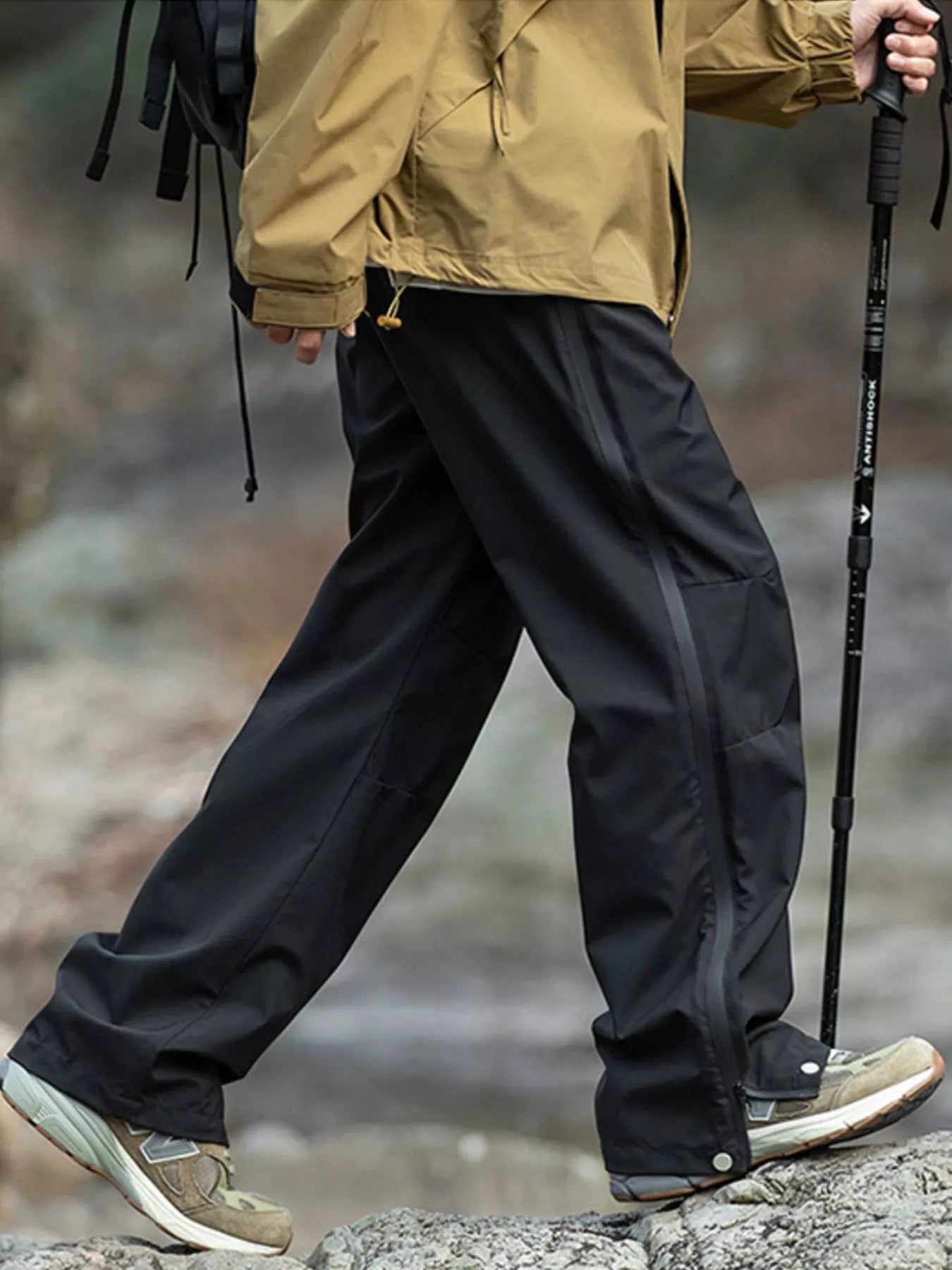 Men's black tactical cargo pants with multiple pockets and a drawstring waist.
