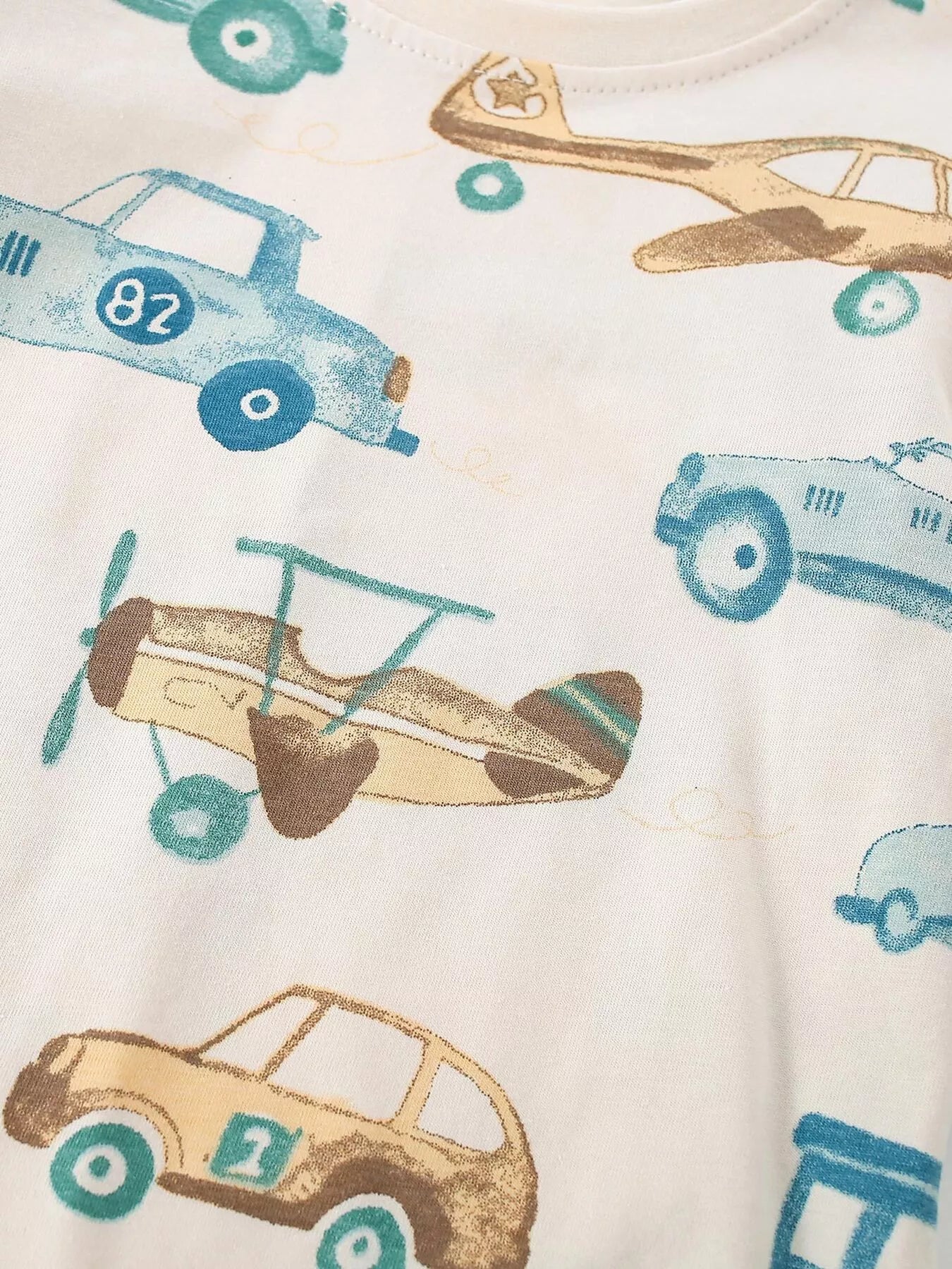 Close up of the transportation print showing blue and tan cars and a propeller airplane