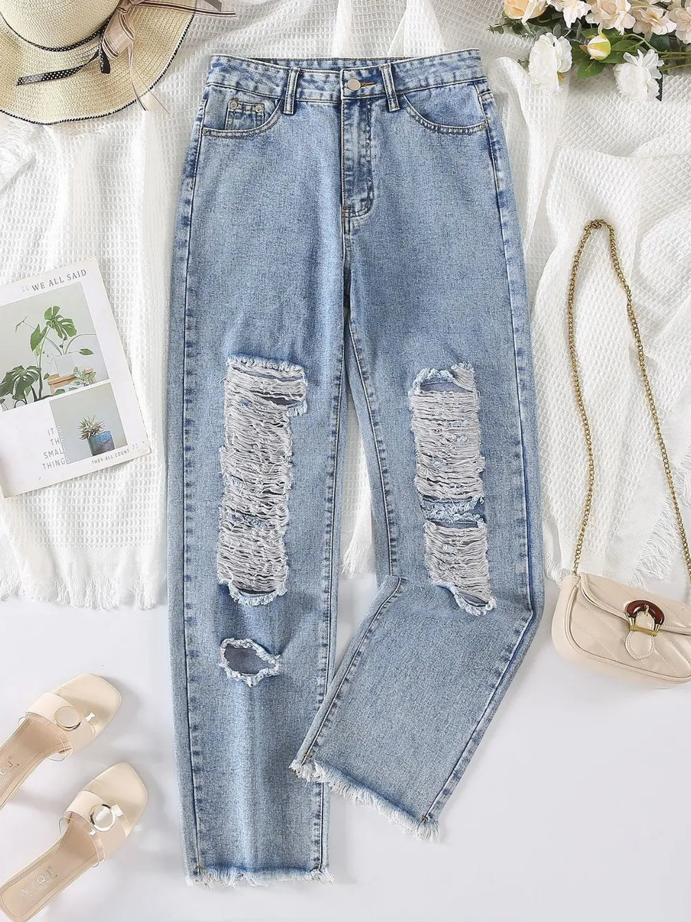 Women's distressed jeans with raw hems, buttons, and pockets.