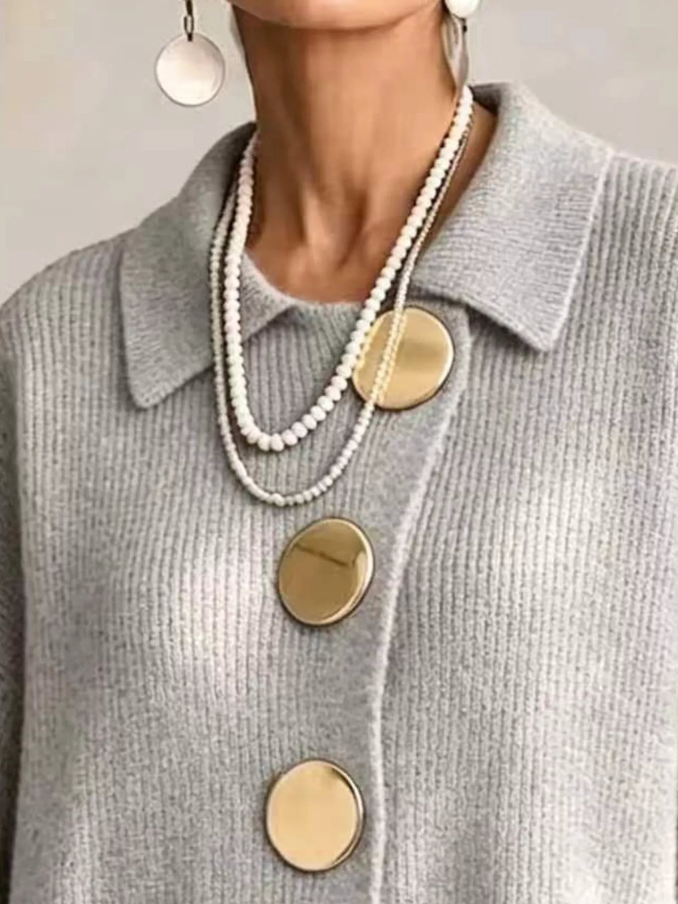 Close up of the light gray cardigan collar and large gold buttons