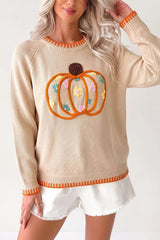 Front view of a beige pumpkin sweater with orange trim at the neckline, cuffs, and hem