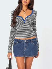 Front view of black and white striped long sleeve t shirt with royal blue trim worn with a denim skirt