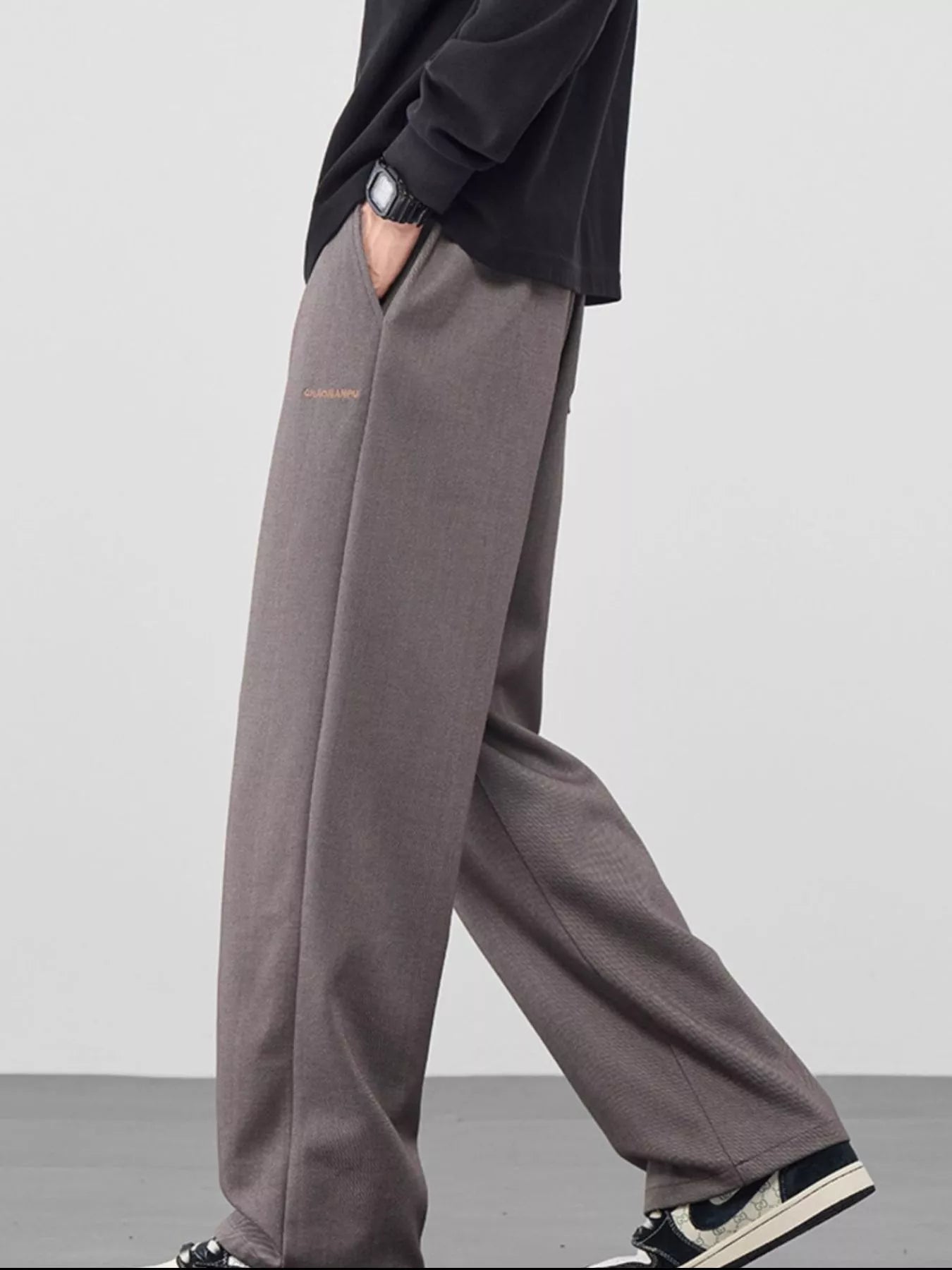 Men's loose fit casual pants with a drawstring waist and pockets.