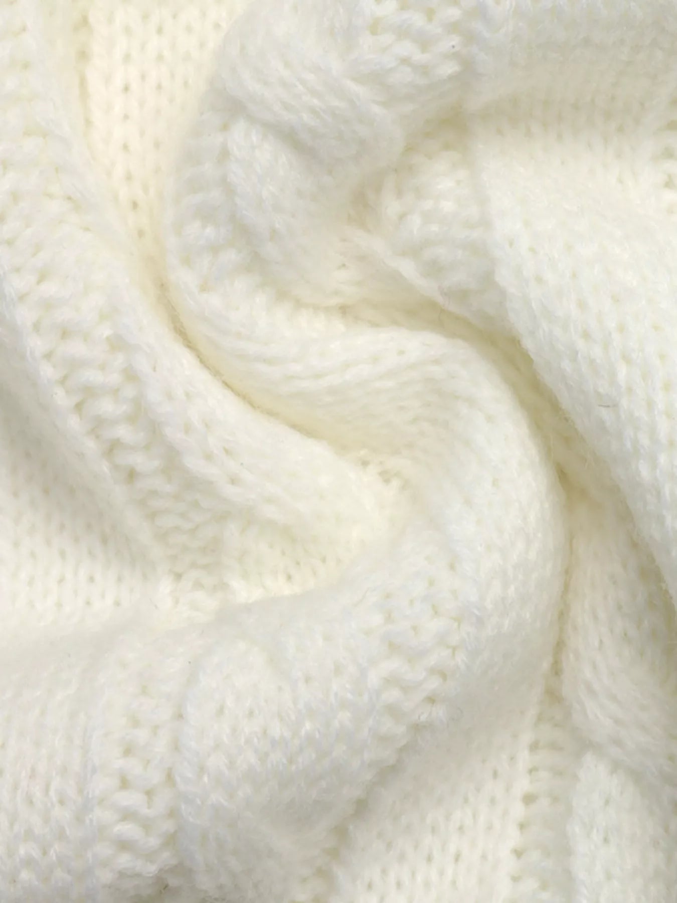 Extreme close up of white cable knit texture showing twisted cable pattern