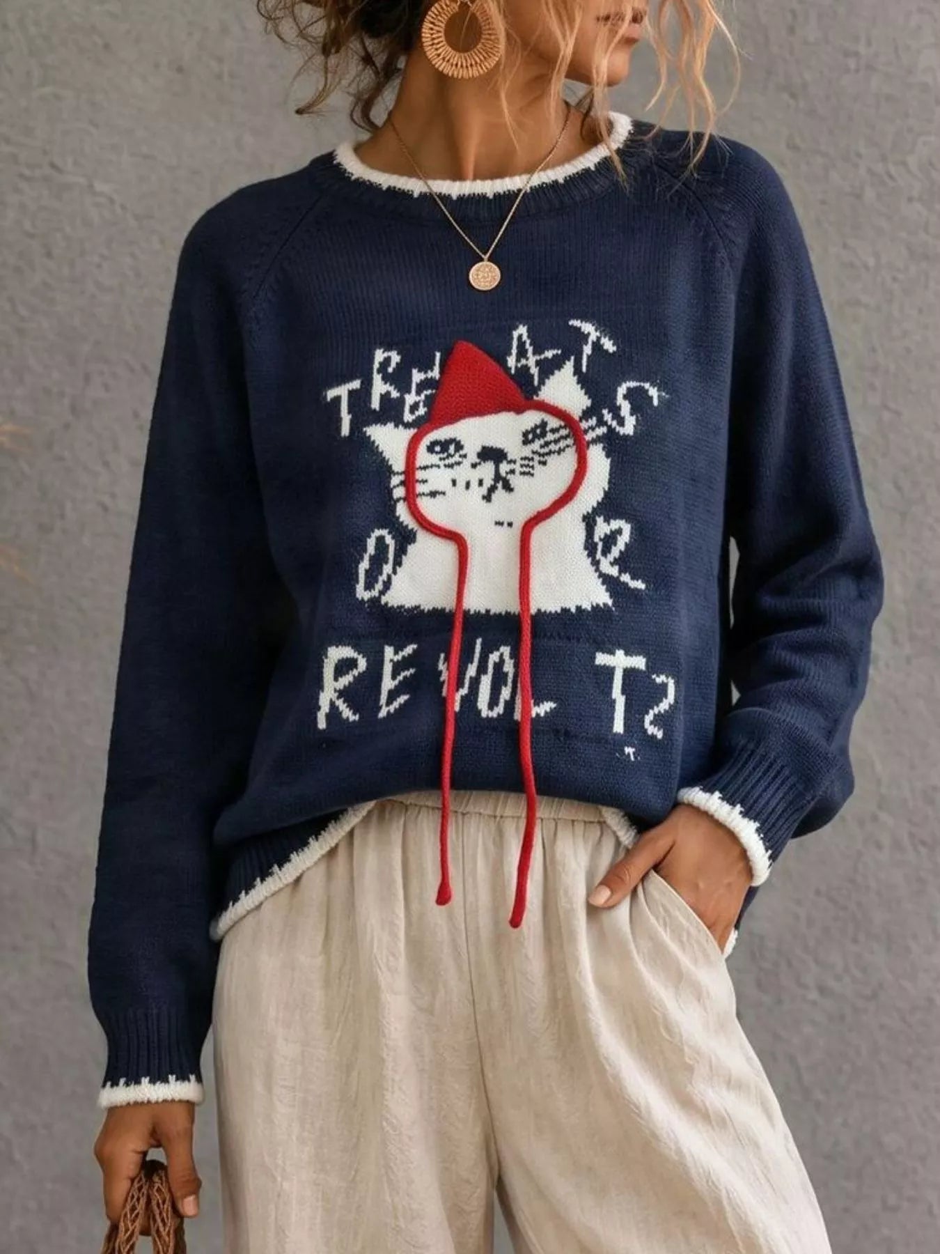 Front view of navy cat sweater with white cat and red strings