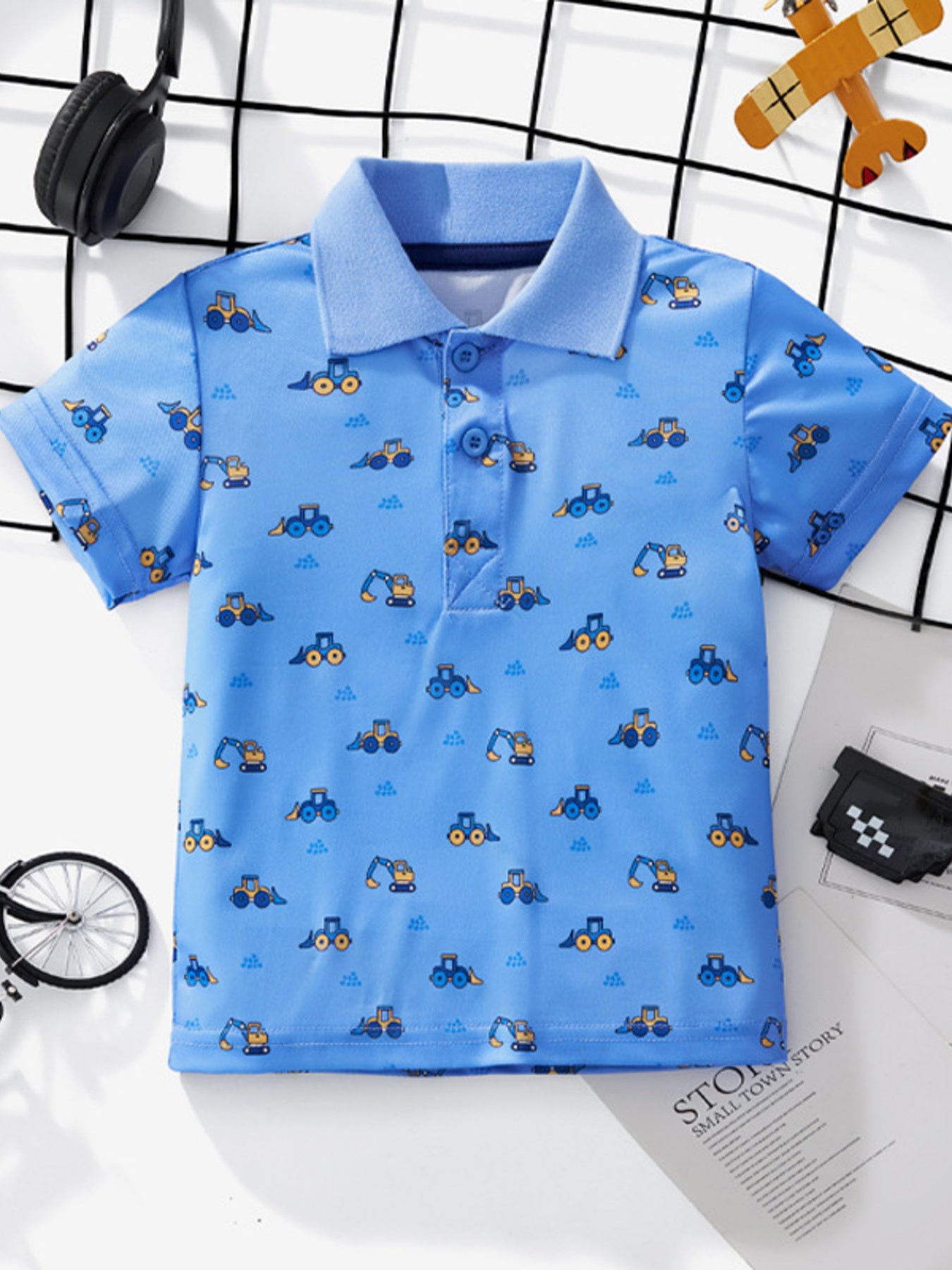 Blue children's short sleeve polo shirt with a small excavator and tractor print